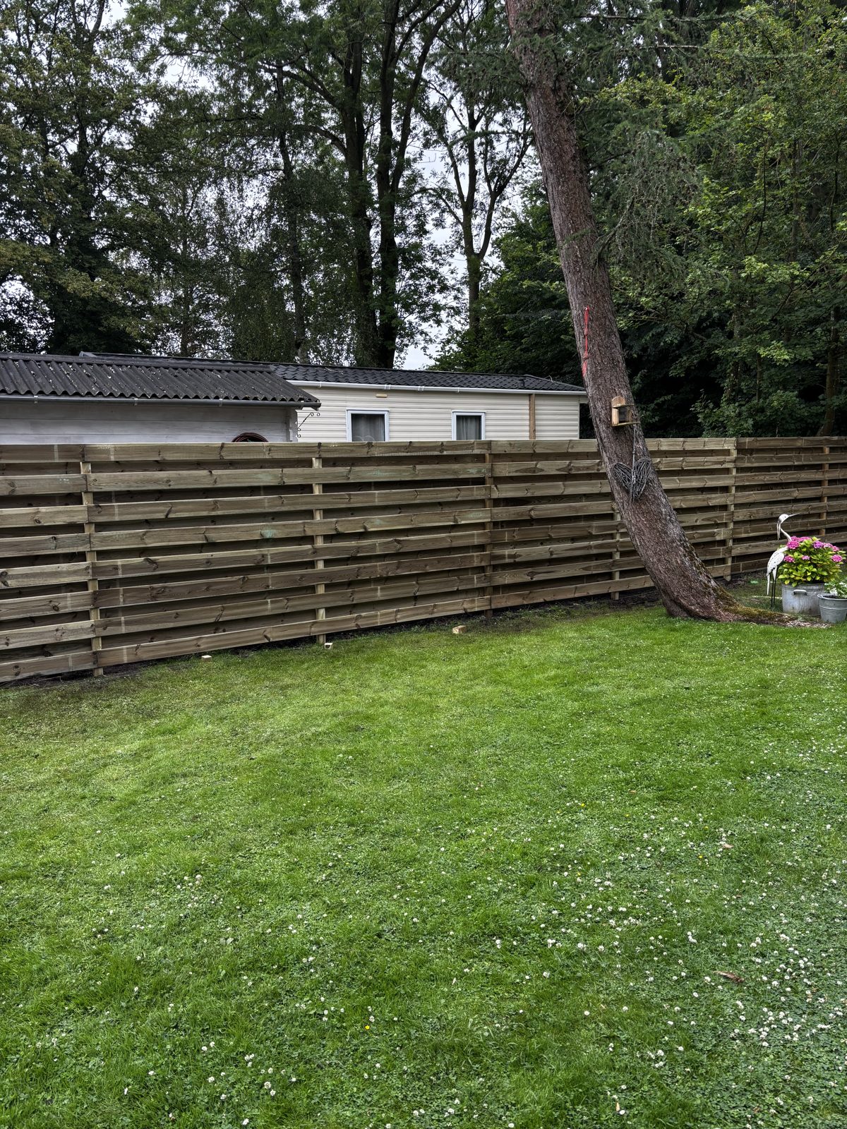 Horizontale grenen schutting langs een gazon