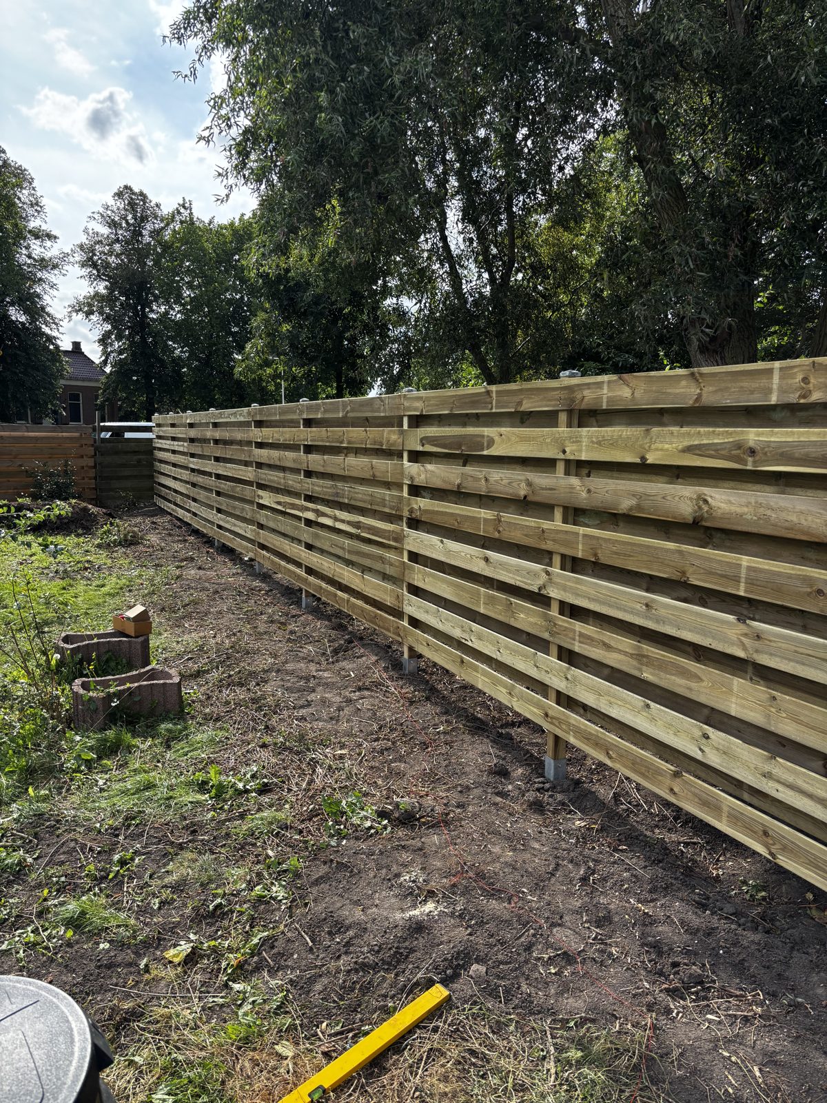 Lange horizontale grenen schutting in een grote tuin